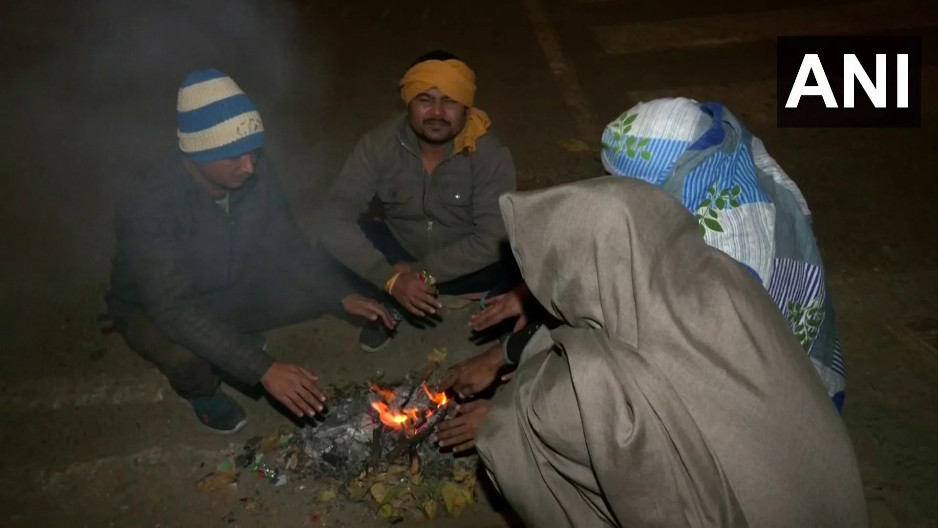 Delhi residents sitting around a bone fire in night