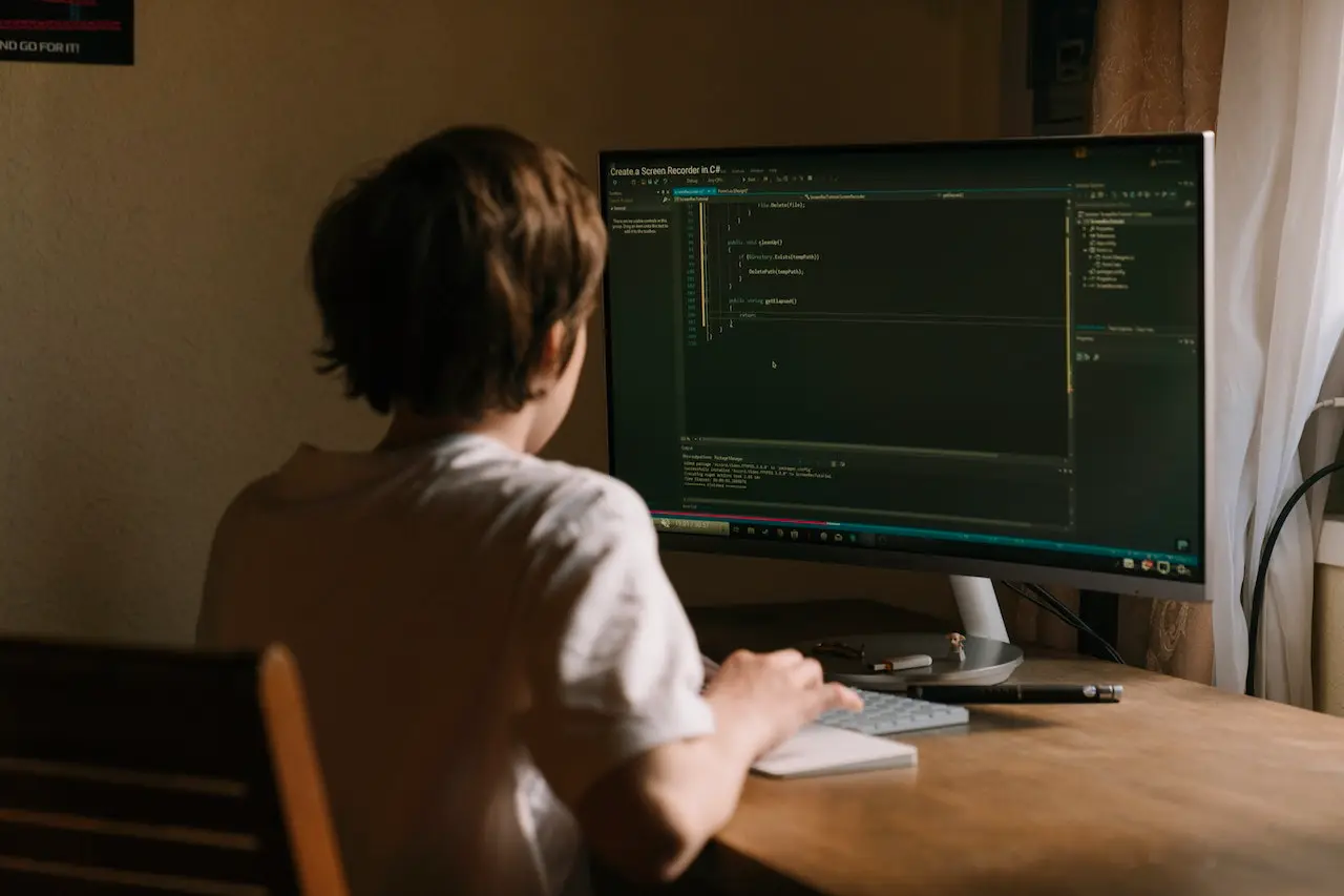 a boy in front of a computer screen.